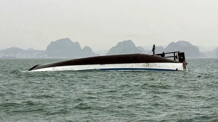 Varias personas de pie en un barco turístico que volcó este sábado en la bahía de Halong, en Vietnam. AFP/Getty Images